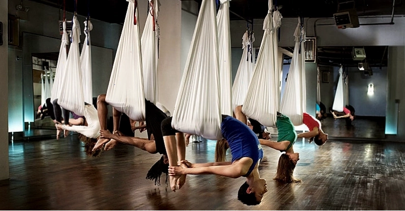 Các học viên thư giãn trong tư thế Savasana trên không tại lớp yoga bay