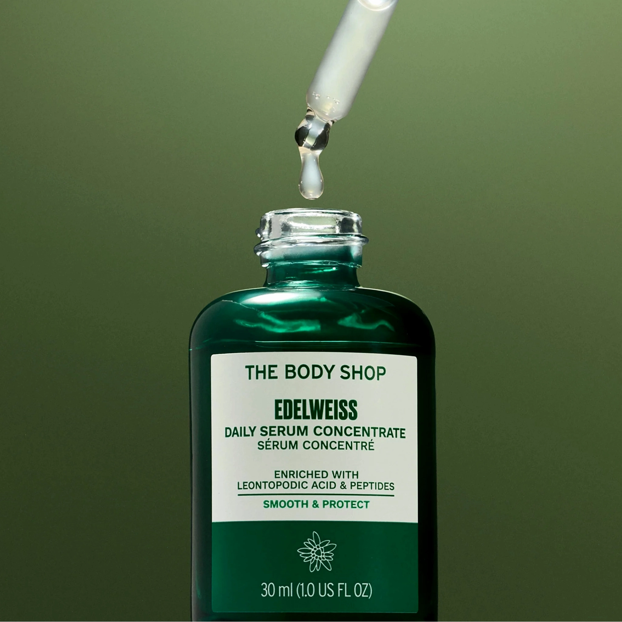 Chai serum Edelweiss với ống nhỏ giọt trên nền xanh lá cây