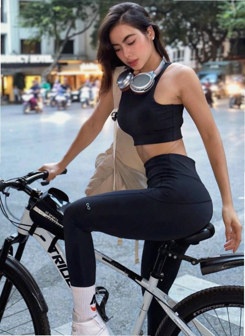 Cô gái tập squat với dây kháng lực tại nhà