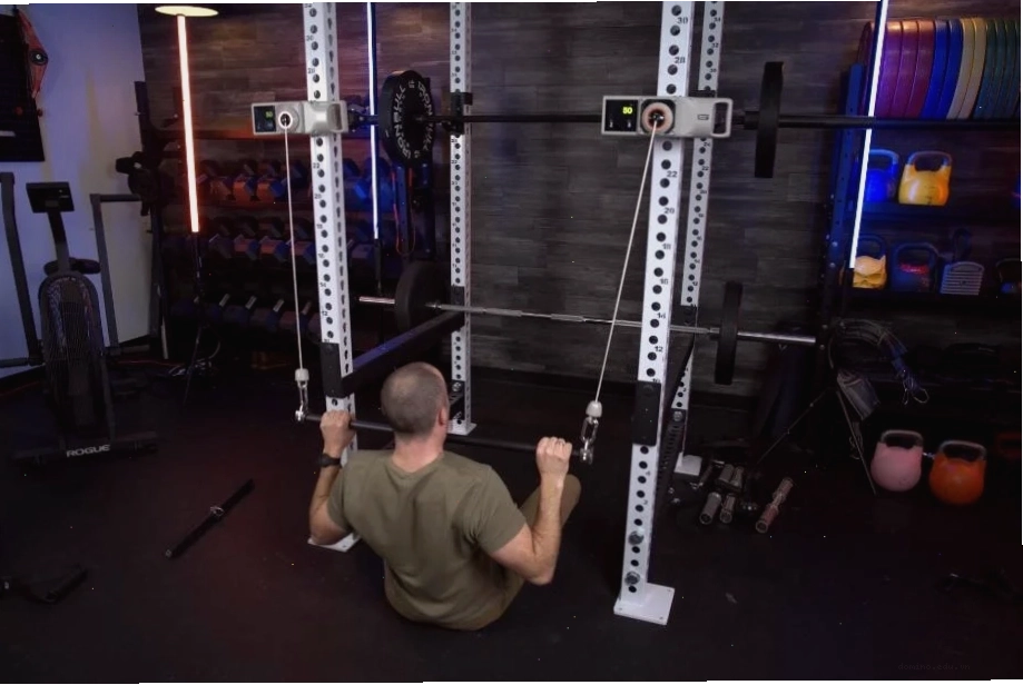 Coop sử dụng hai máy Beyond Power Voltra I để thực hiện bài tập lat pulldowns