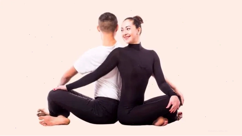 Hai người tập yoga đôi cùng nhau thực hiện tư thế