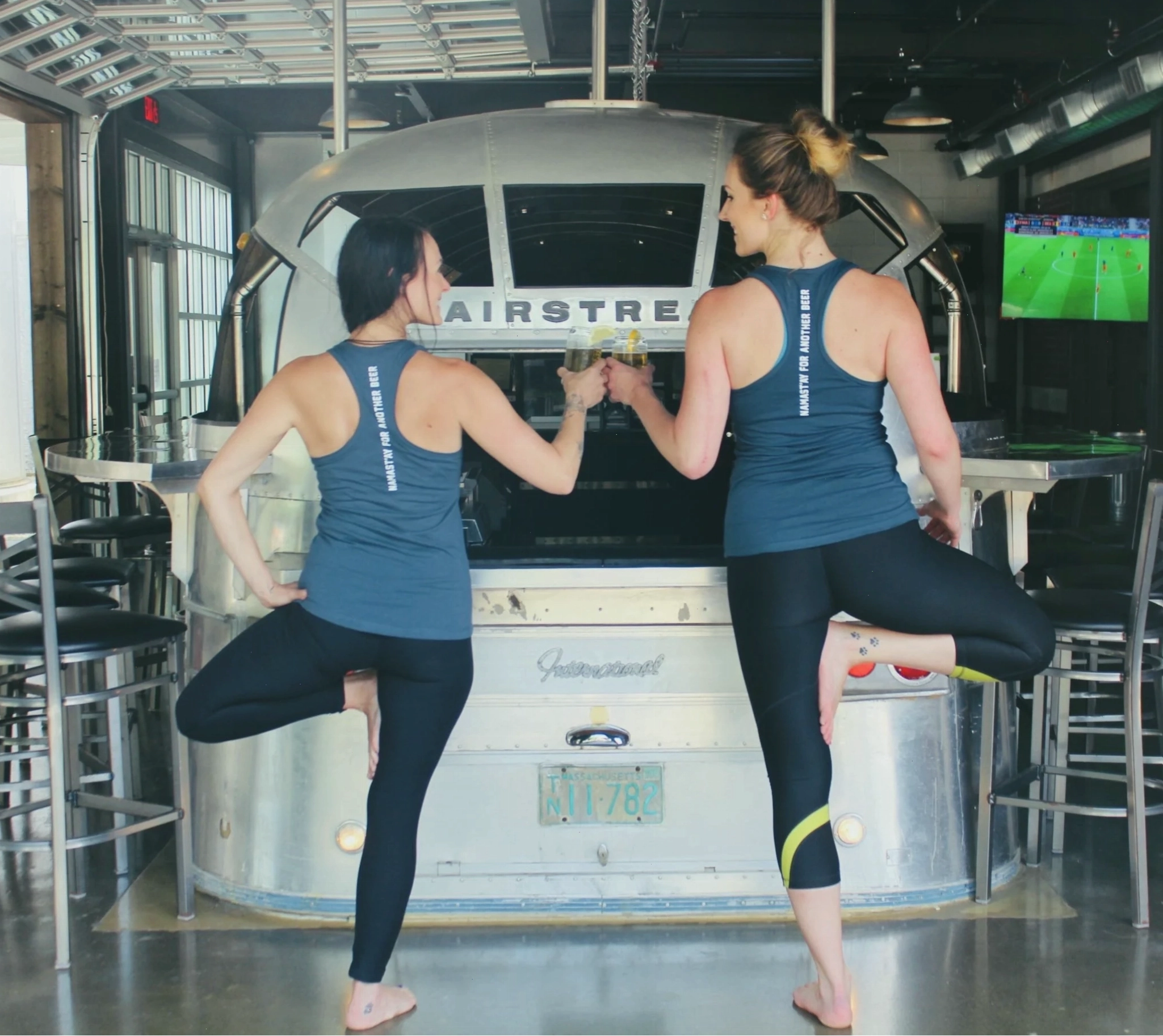 Hai phụ nữ tập tư thế cây đứng trên thảm yoga