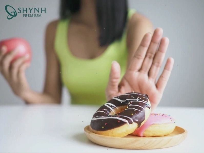 Hình ảnh người từ chối món ăn vặt không lành mạnh thể hiện sự kiểm soát cơn thèm ăn