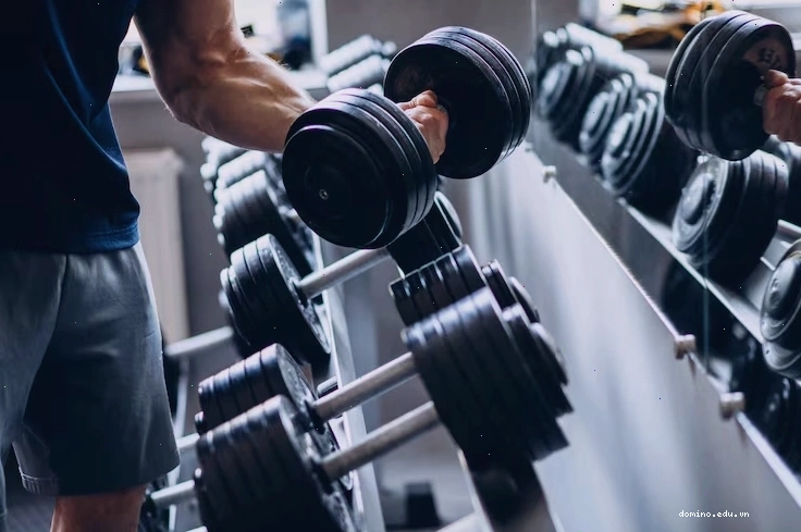 Hình nền người đàn ông mạnh mẽ đang tập luyện trong phòng gym