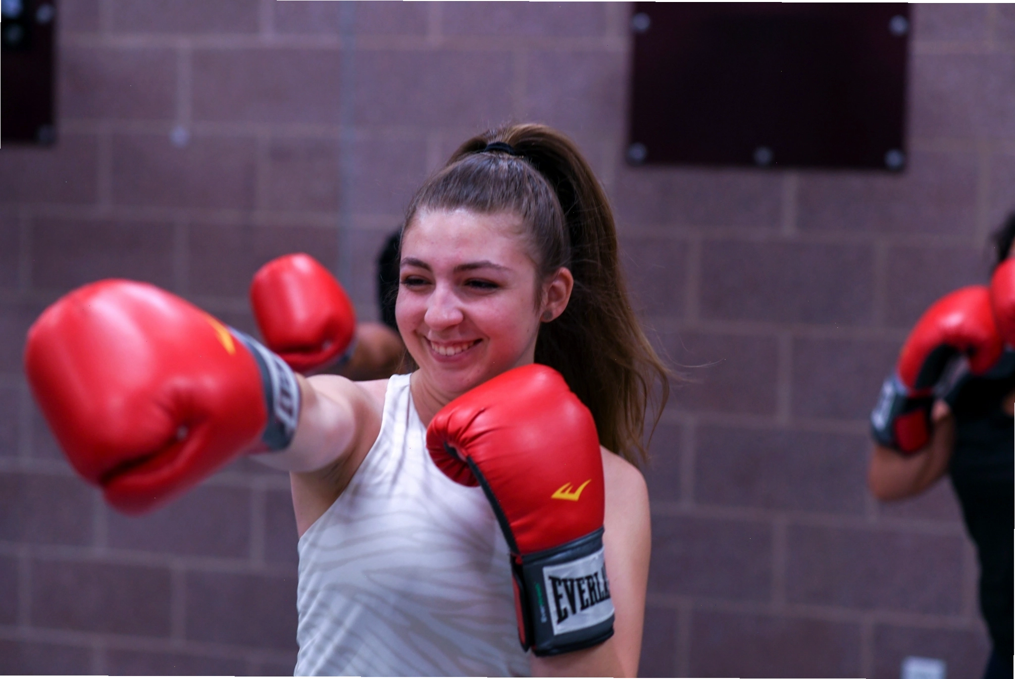 Học viên đeo găng tay boxing đỏ tập luyện cú đấm