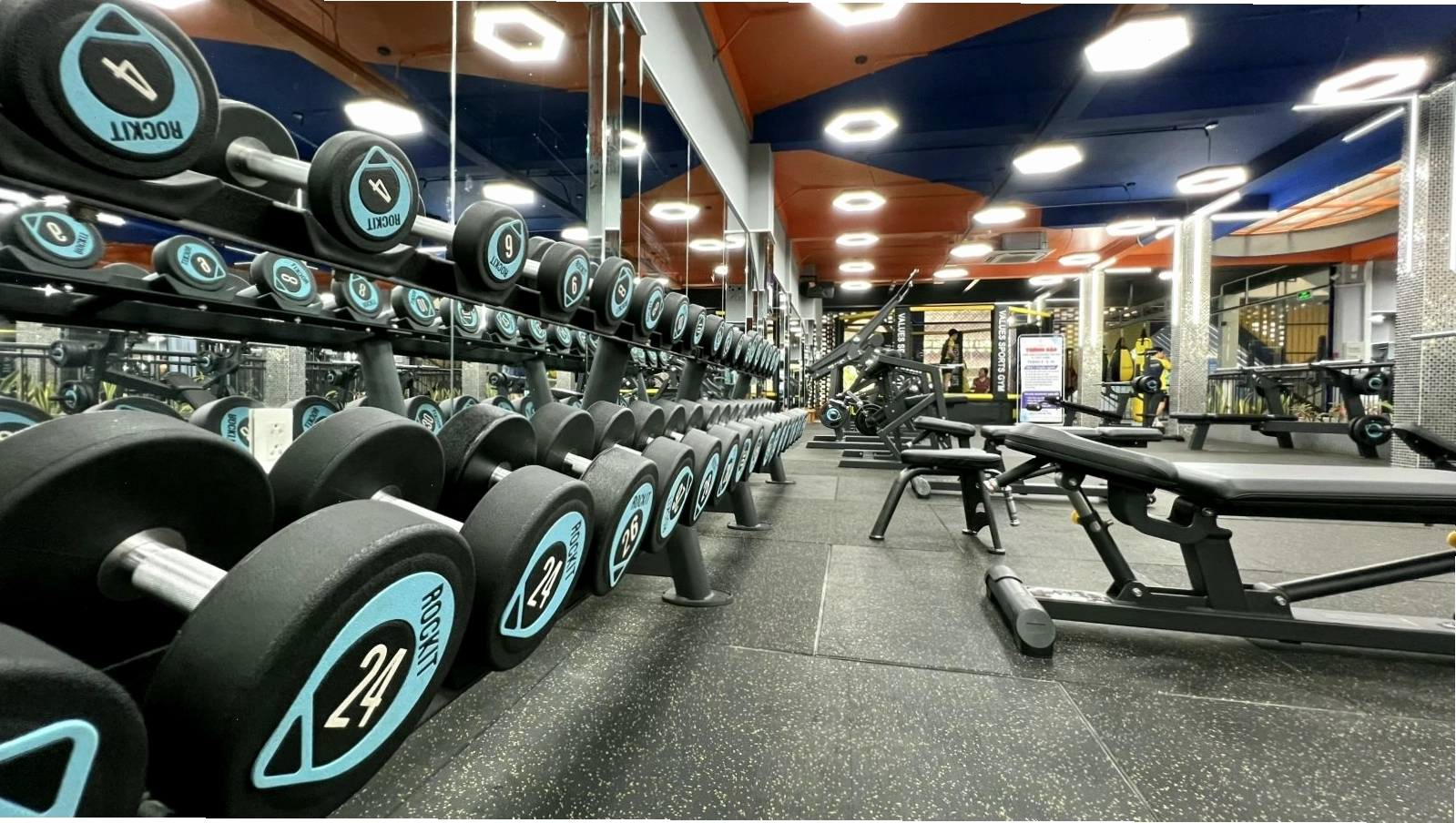 Huấn luyện viên đang hướng dẫn một hội viên thực hiện bài tập tại Values Sports Gym