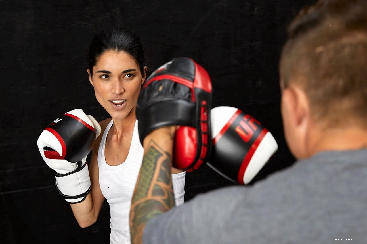 Huấn luyện viên hướng dẫn thành viên tập luyện đấm bao cát tại UFC GYM