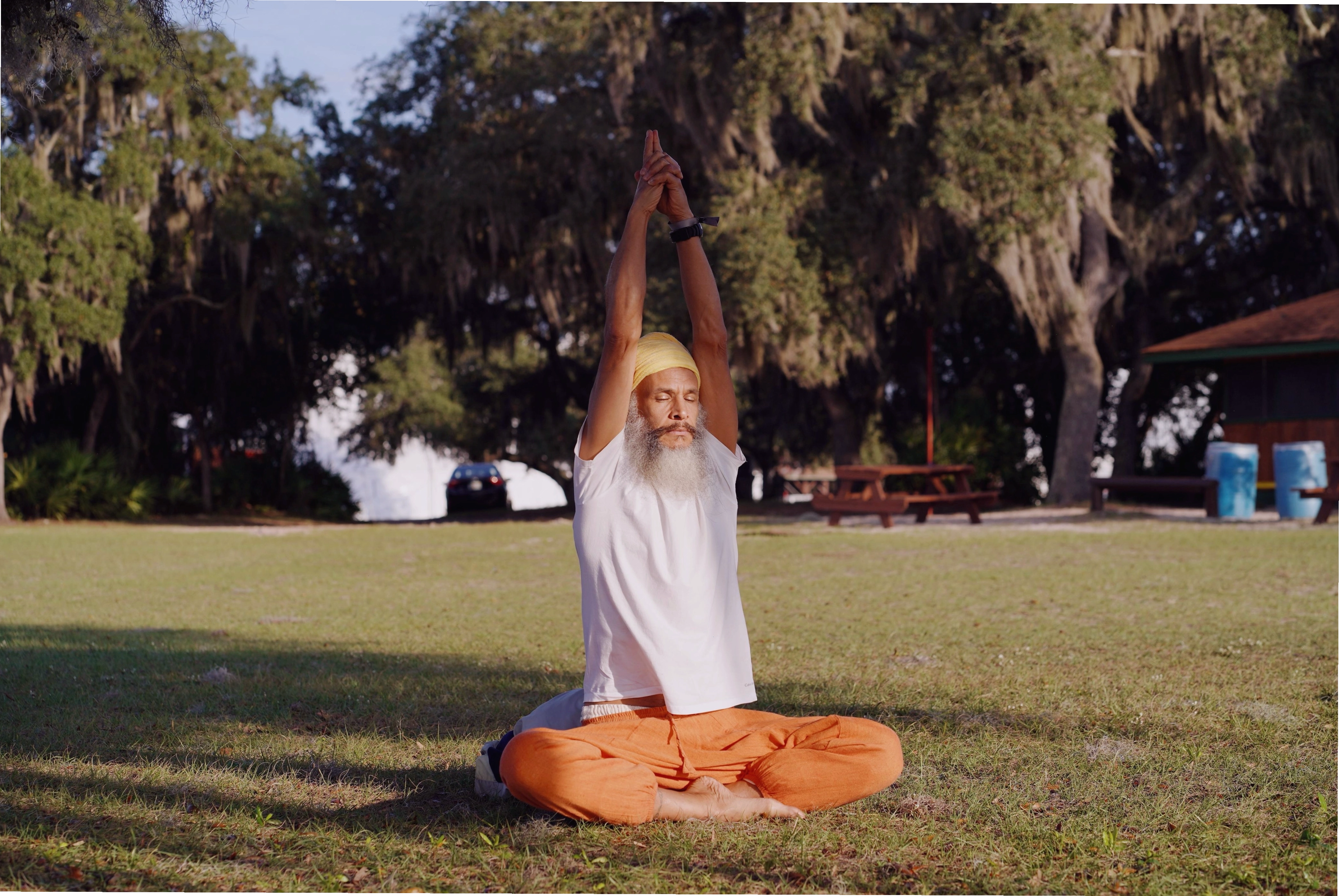 Maestro de kundalini yoga practicando meditación sentado al aire libre