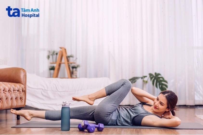 Mẹ thực hiện bài tập gập bụng đạp xe giảm mỡ bụng sau sinh