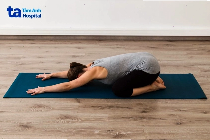 Mẹ thực hiện bài tập tư thế em bé giảm mỡ bụng sau sinh