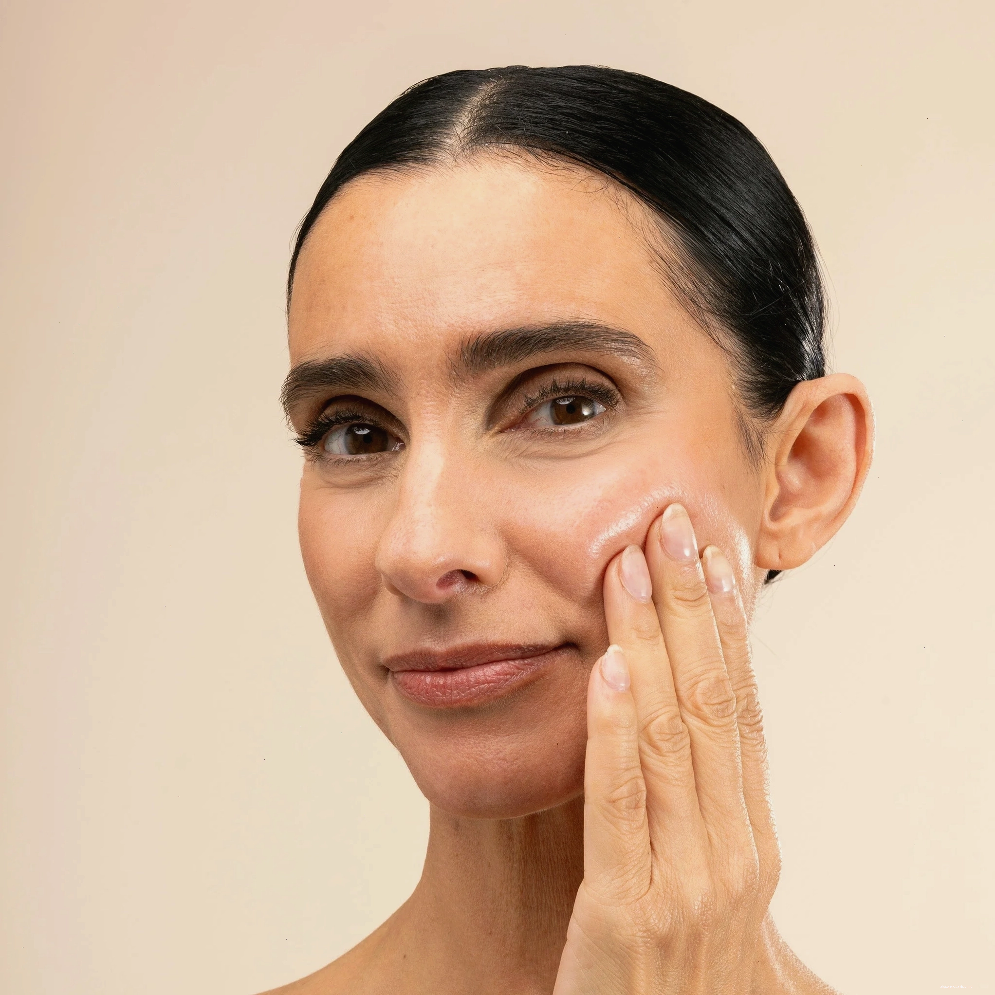 Một người phụ nữ thoa serum lên mặt