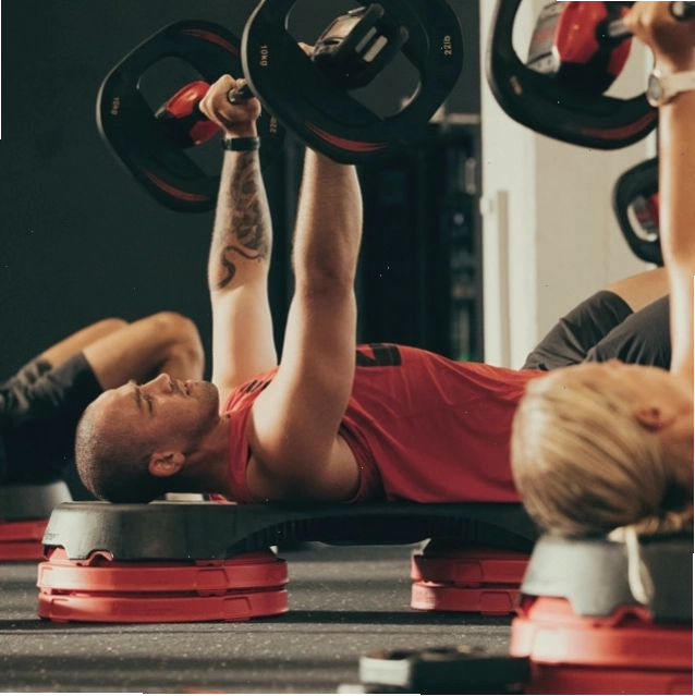 Nam giới nâng tạ với thanh tạ trong lớp thể dục nhóm LES MILLS BODYPUMP