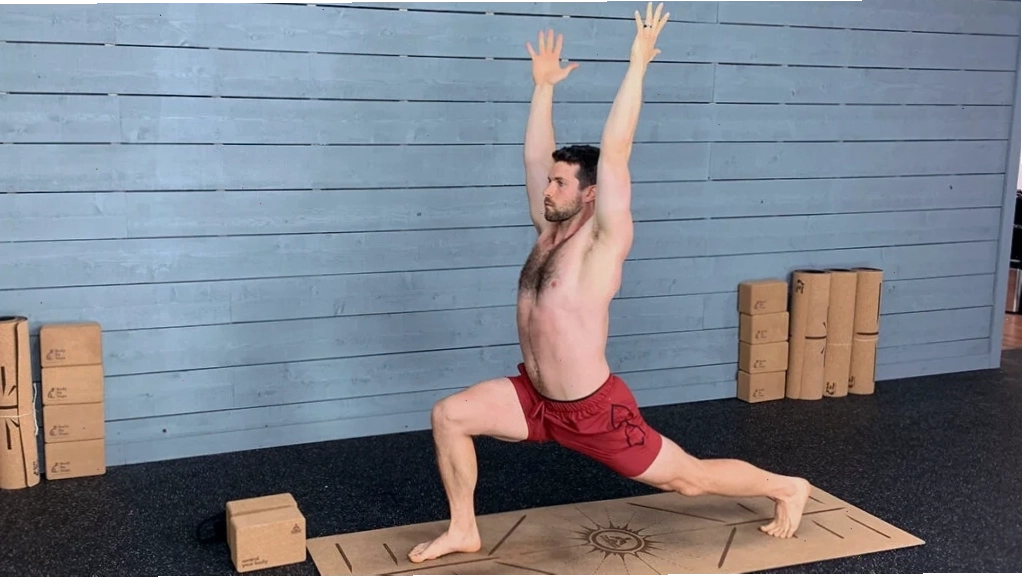 Nam giới thực hiện tư thế gập người về phía trước (Forward Fold) để kéo giãn gân kheo và hông