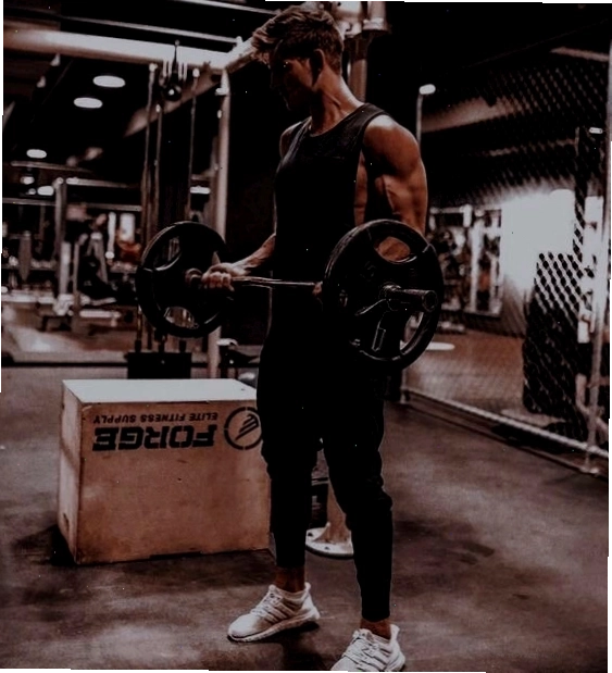 Nam gymer tập tạ đòn, hai chân rộng bằng vai, tay nâng tạ ngang bụng khoe cơ tay