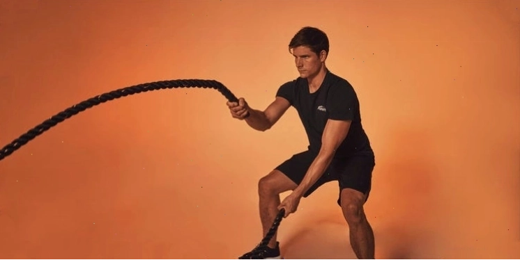Người đàn ông thực hiện bài tập với dây thừng trong phòng gym