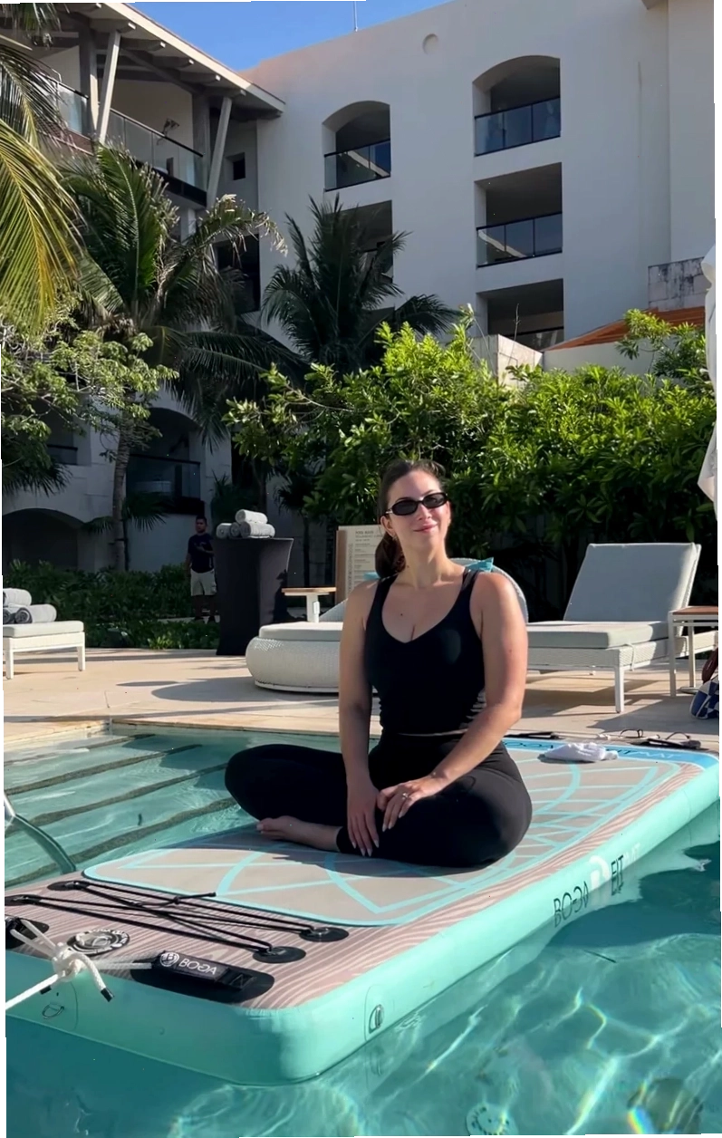 Người phụ nữ tập yoga trên thảm nổi giữa hồ bơi
