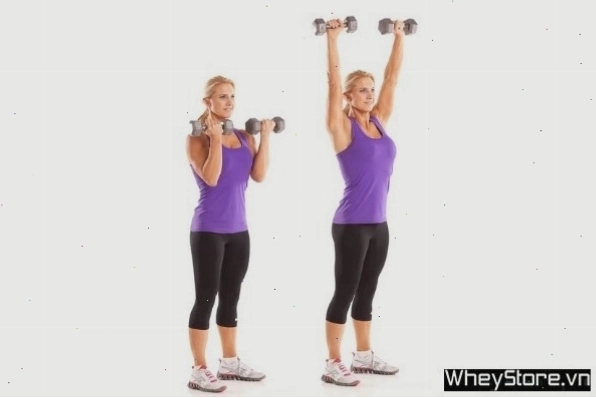 Người phụ nữ thực hiện bài tập đẩy vai qua đầu với tạ đơn (Dumbbell Overhead Press)