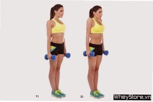 Người phụ nữ thực hiện bài tập nhún vai (Shoulder Shrug) với tạ đơn