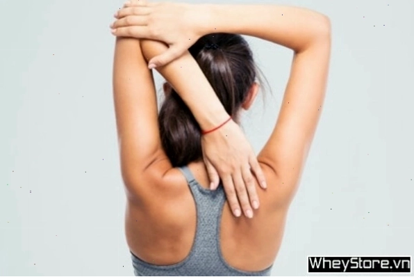 Người phụ nữ thực hiện động tác kéo giãn cơ bắp tay