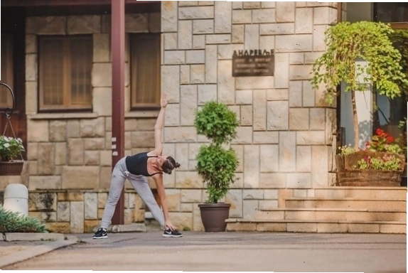Người phụ nữ trẻ tập luyện với bức tường gạch làm phông nền, thể hiện sự mạnh mẽ và quyết tâm