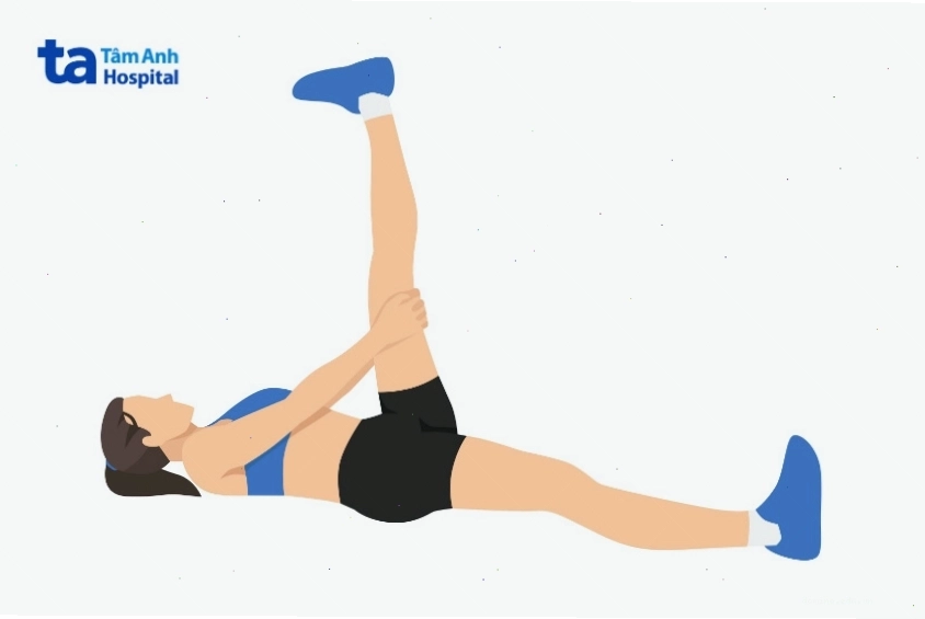 Người tập đang thực hiện bài tập nằm duỗi gân kheo, cảm nhận sự kéo giãn ở mặt sau đùi.