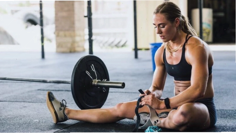 Người tập gym nữ đang thực hiện bài tập vai với tạ đơn