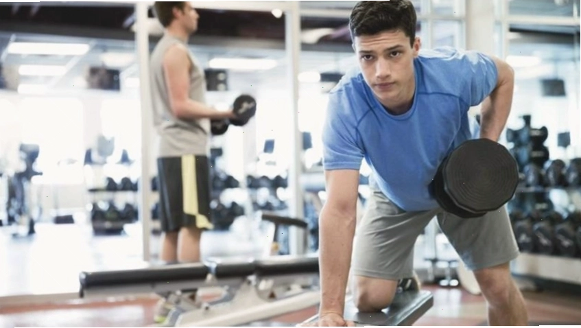Người tập gym thực hiện động tác squat với tạ đơn, chú trọng kỹ thuật