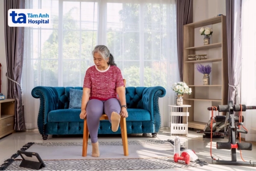 Người tập ngồi thực hiện bài tập đá chân thẳng, tập trung vào cơ tứ đầu đùi.