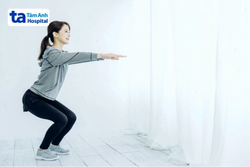 Người tập thực hiện bài tập Squat nửa gối với sự hỗ trợ của bóng và tường.