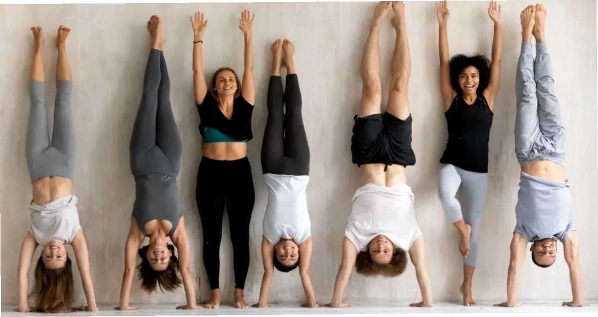 Người tập yoga đang thực hiện tư thế handstand với sự hỗ trợ của tường