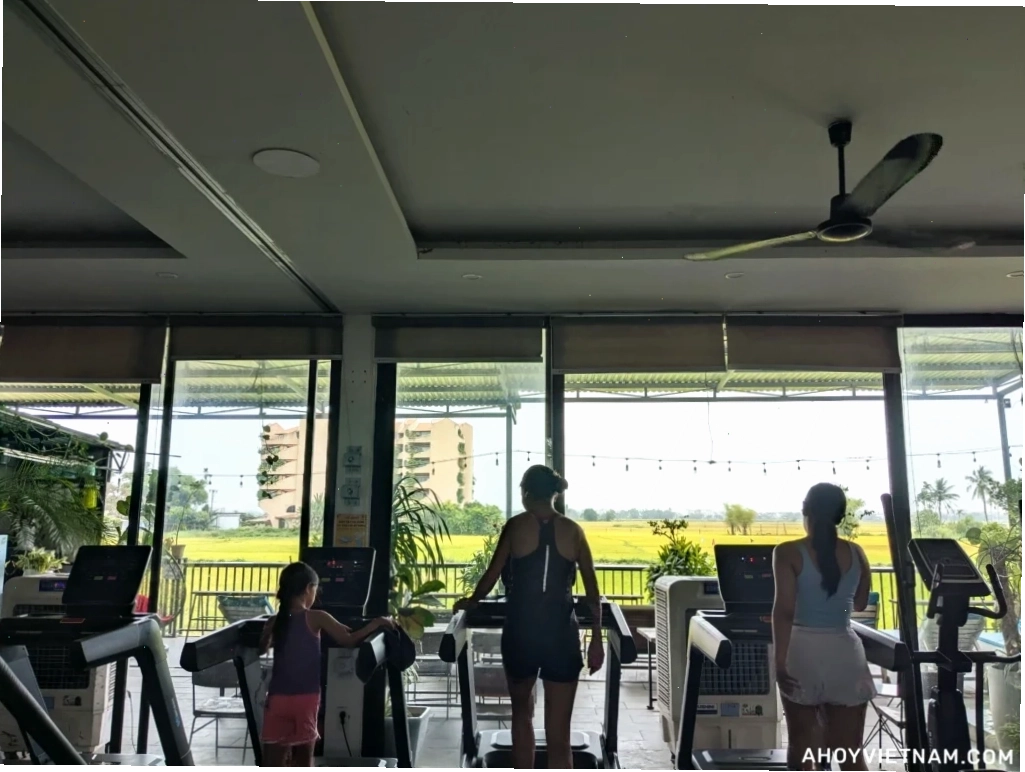 People on treadmills overlooking the rice fields at HealthFit Gym in Hoi An