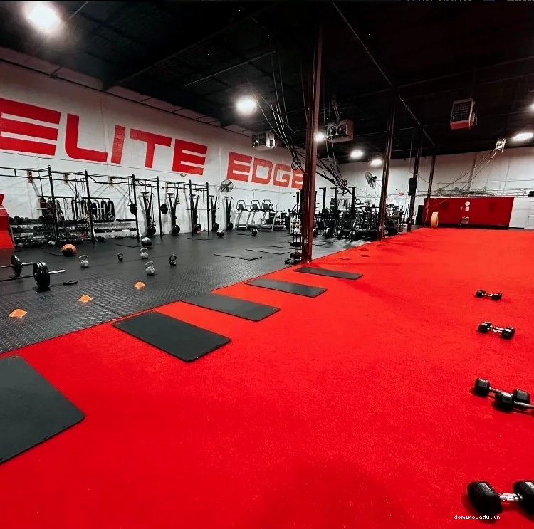 Phòng gym với tông màu đỏ đen, trang bị tạ, thảm và tạ tự do