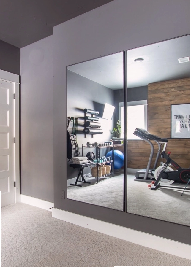 Phòng gym với tường sơn xám và gương treo tường