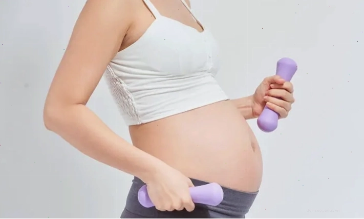 Phụ nữ mang thai đi bộ nhẹ nhàng trong công viên xanh mát