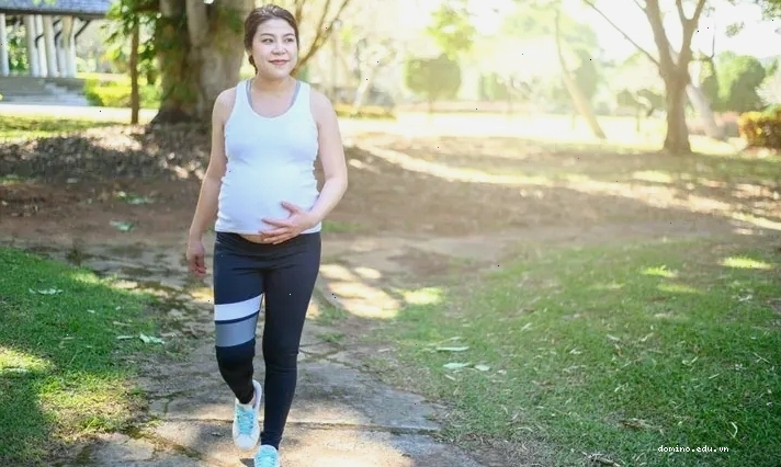 Phụ nữ mang thai nâng tạ nhẹ trong phòng tập