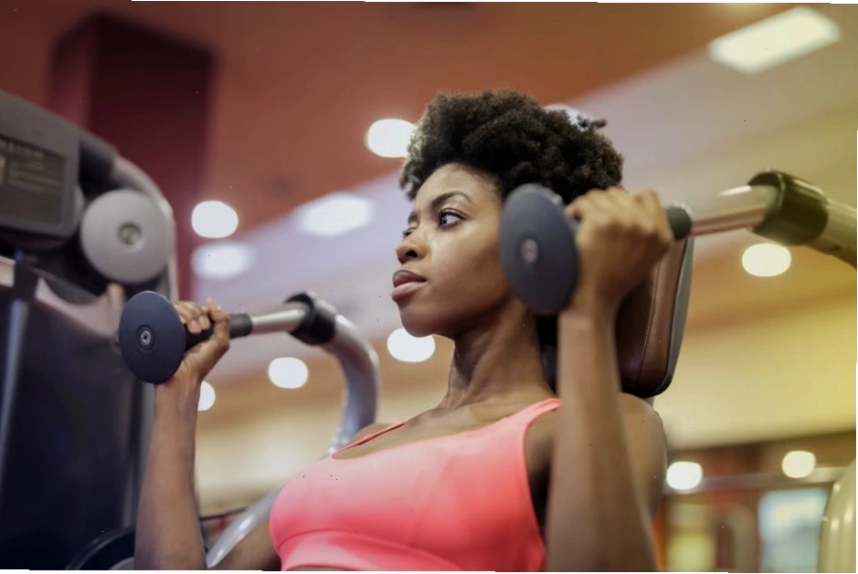 Phụ nữ theo dõi sự tiến bộ trong quá trình chuyển đổi cơ thể tại phòng gym