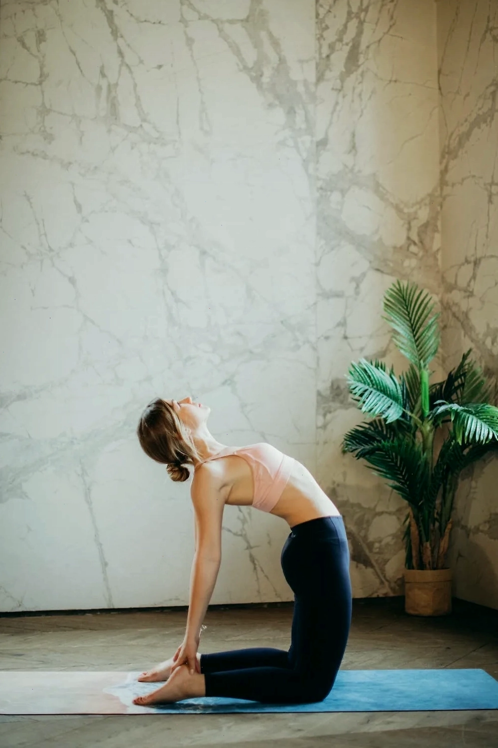 Phụ nữ thực hiện bài tập yoga trên thảm