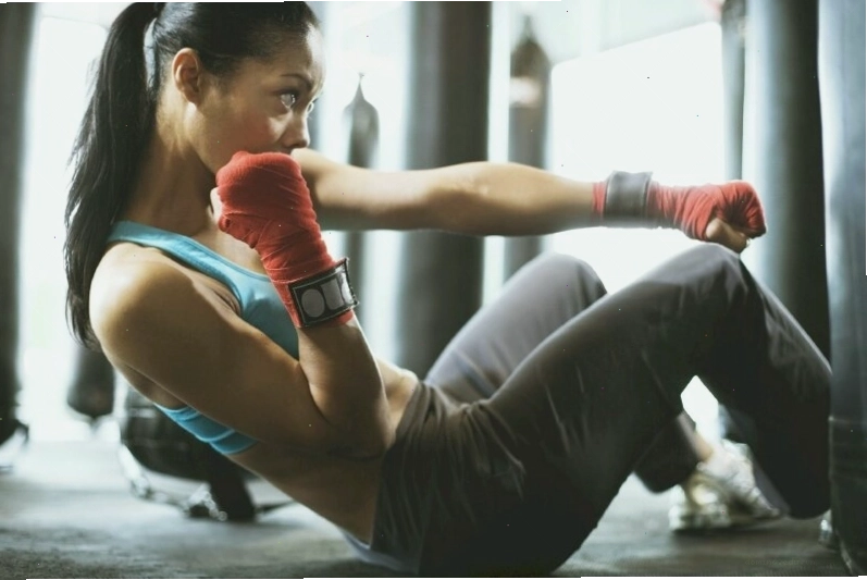 Tạo dáng gymer nữ đánh boxing trong tư thế ngồi gập bụng