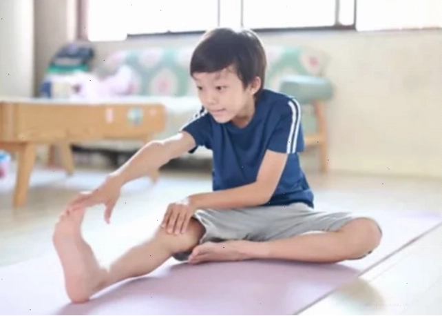 Trẻ thực hiện động tác chạm ngón chân để giãn cơ chân