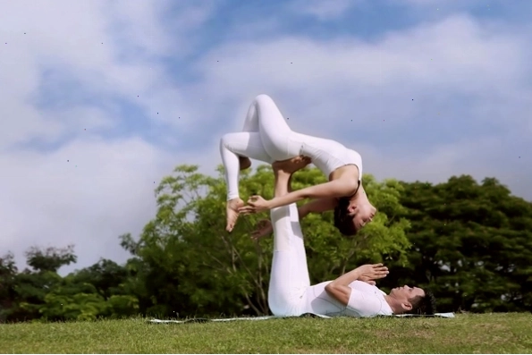 Tư thế chiếc thuyền trong Yoga đôi, hai người ngồi đối diện, chân và tay chạm nhau