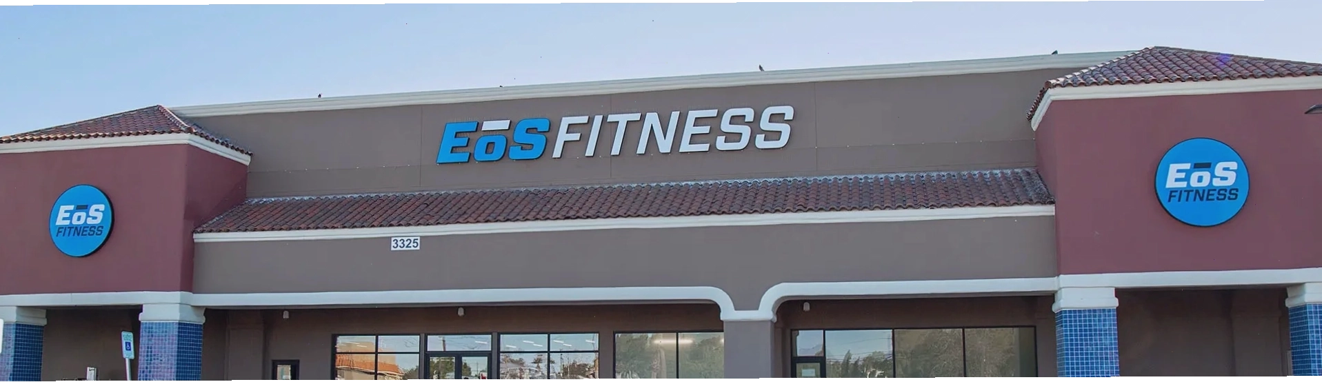 Vim + Vigor Fitness - Thiết kế bên ngoài hiện đại với tường gạch và thương hiệu màu xanh dương